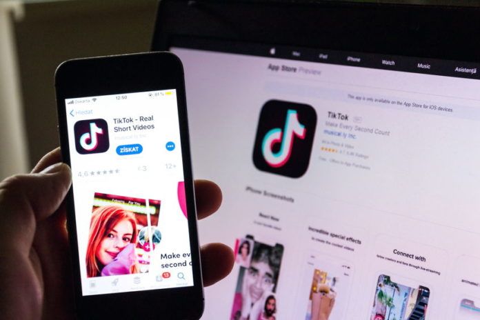 PRAGUE, CZECH REPUBLIC - NOVEMBER 22 2018: TikTok mobile video-sharing app company logo on phone screen with internet homepage in background on November 22, 2018 in Prague, Czech republic.