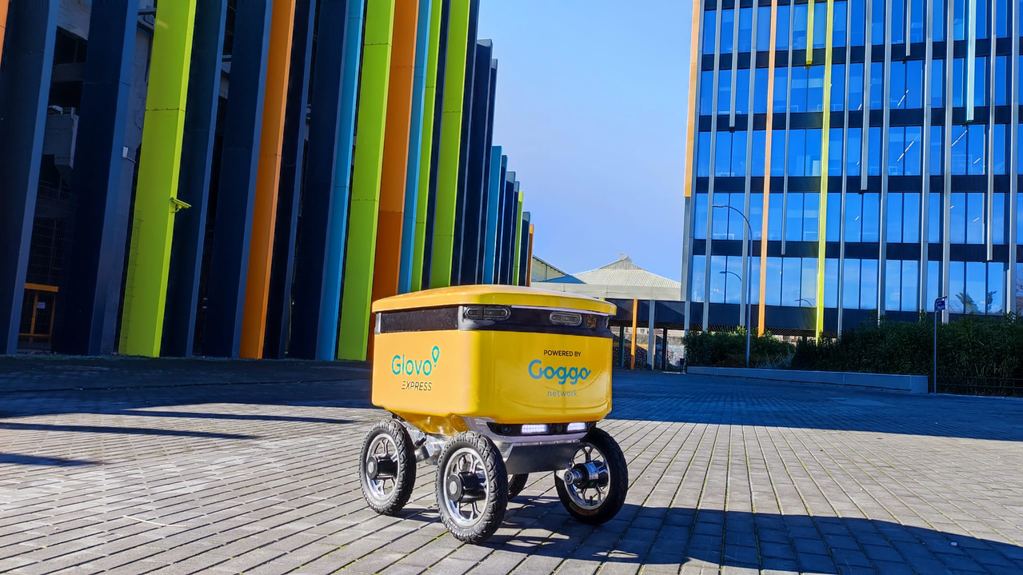 El robot de delivery se dirigirá de forma autónoma hasta el edificio del cliente y una vez llegue, le avisará para recoger su pedido. El robot de delivery se dirigirá de forma autónoma hasta el edificio del cliente y una vez llegue, le avisará para recoger su pedido.