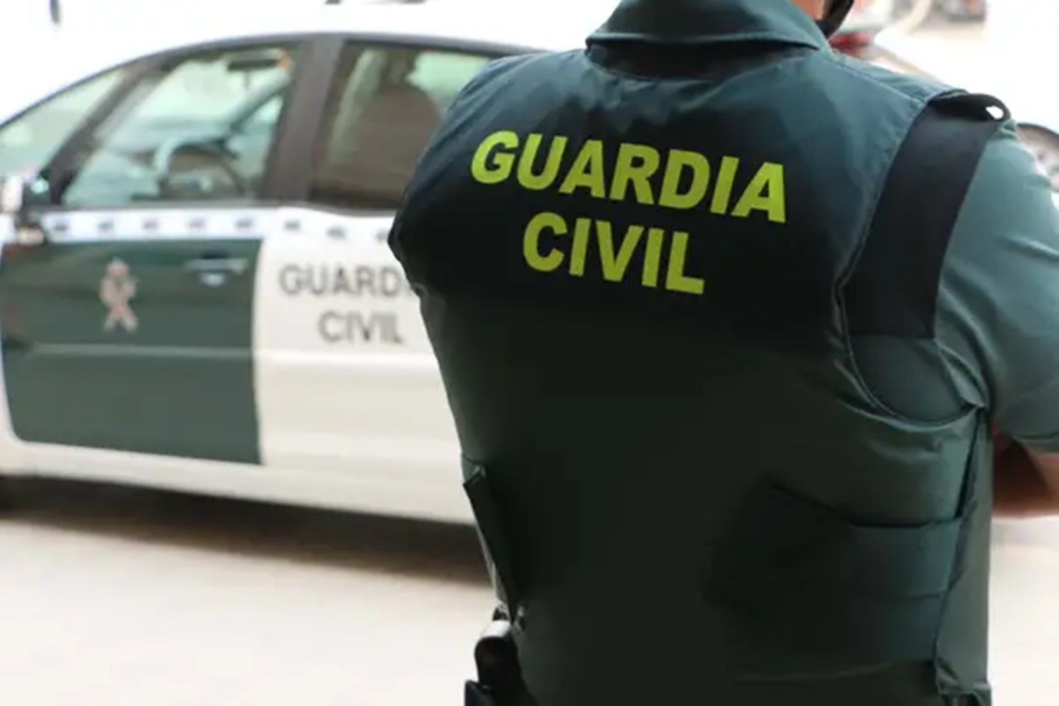 Agente de la Guardia Civil con un coche del cuerpo de fondo | Foto: Guardia Civil
