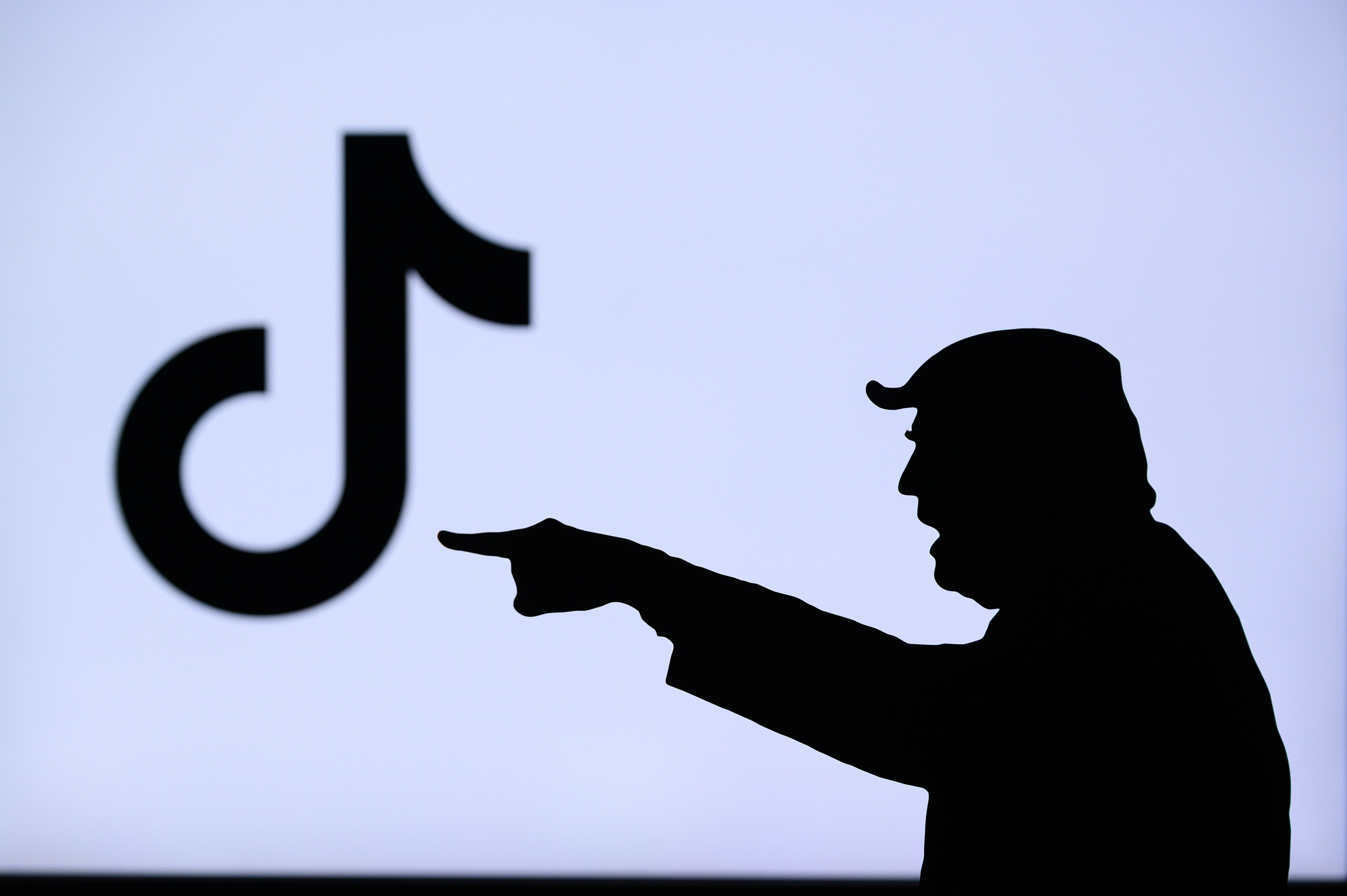 Isotipo de TikTok frente a silueta de Donald Trump. Isotipo de TikTok frente a silueta de Donald Trump.