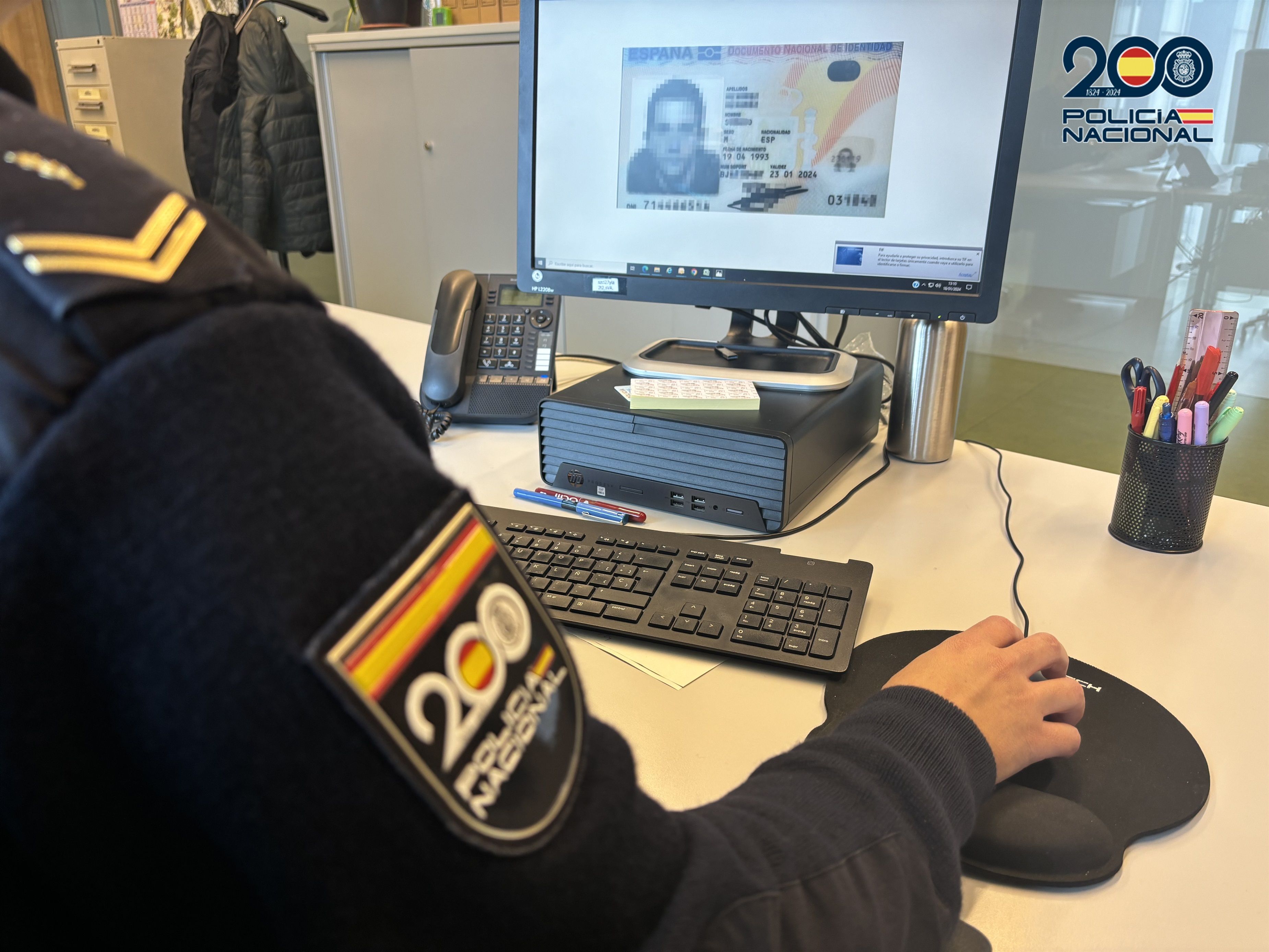 Agente de la Policía Nacional frente a un ordenador en el que aparece la imagen de un DNI (Foto: Policía Nacional)