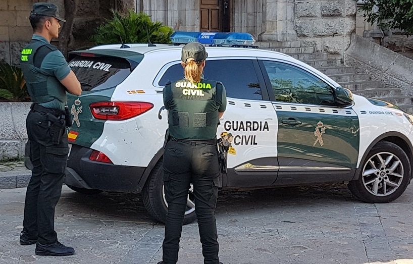 Dos agentes de la Guardia Civil junto a un coche oficial del cuerpo (Foto: Guardia Civil)
