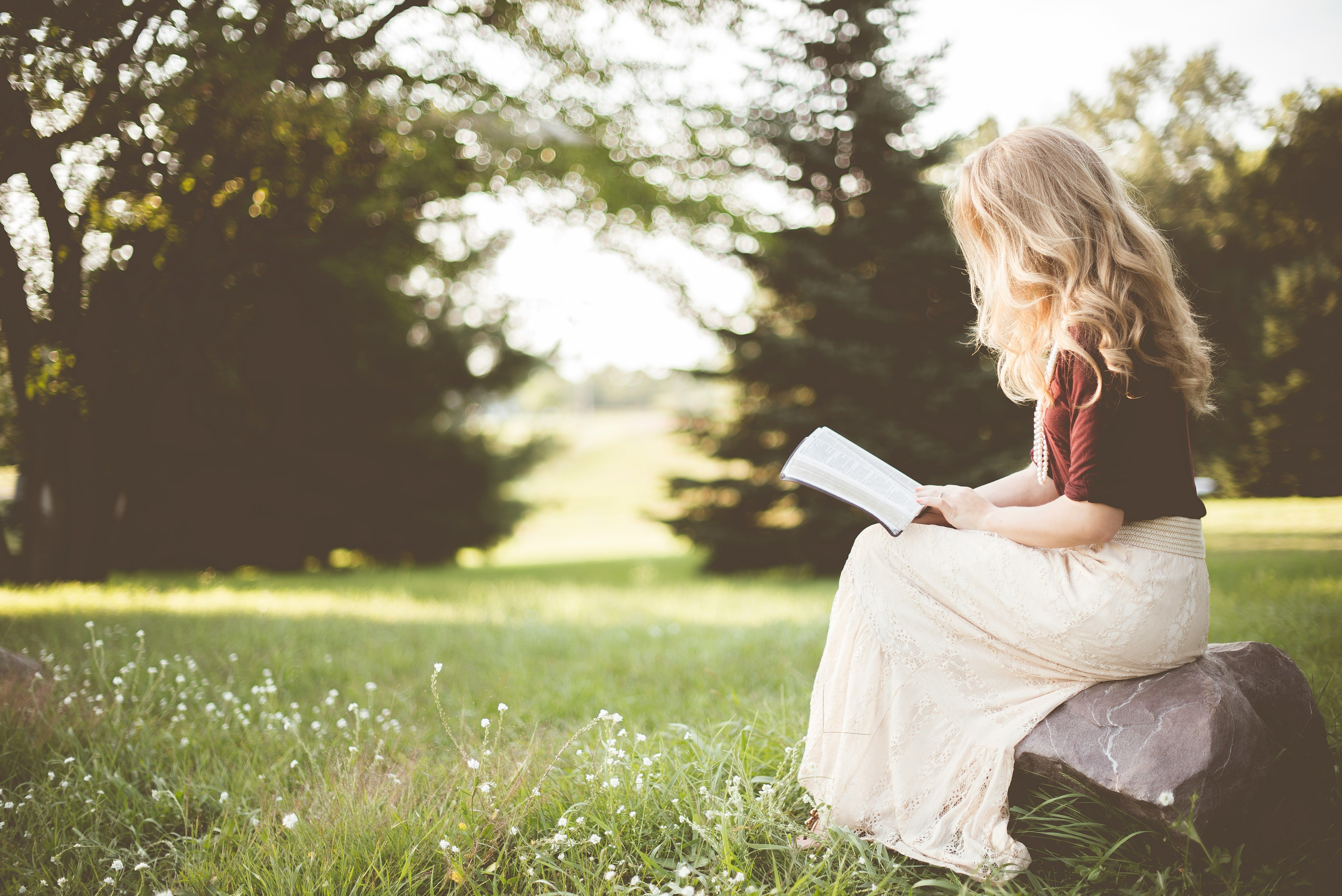 Mujer leyendo un libro en la naturaleza