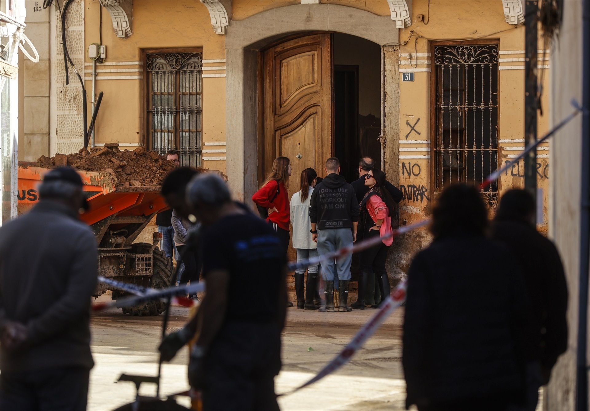 Varias personas en una calle cubierta de barro, el 28 de noviembre, en Paiporta, localidad castigada por la DANA. Foto: Europa Press / Rober Solsona.