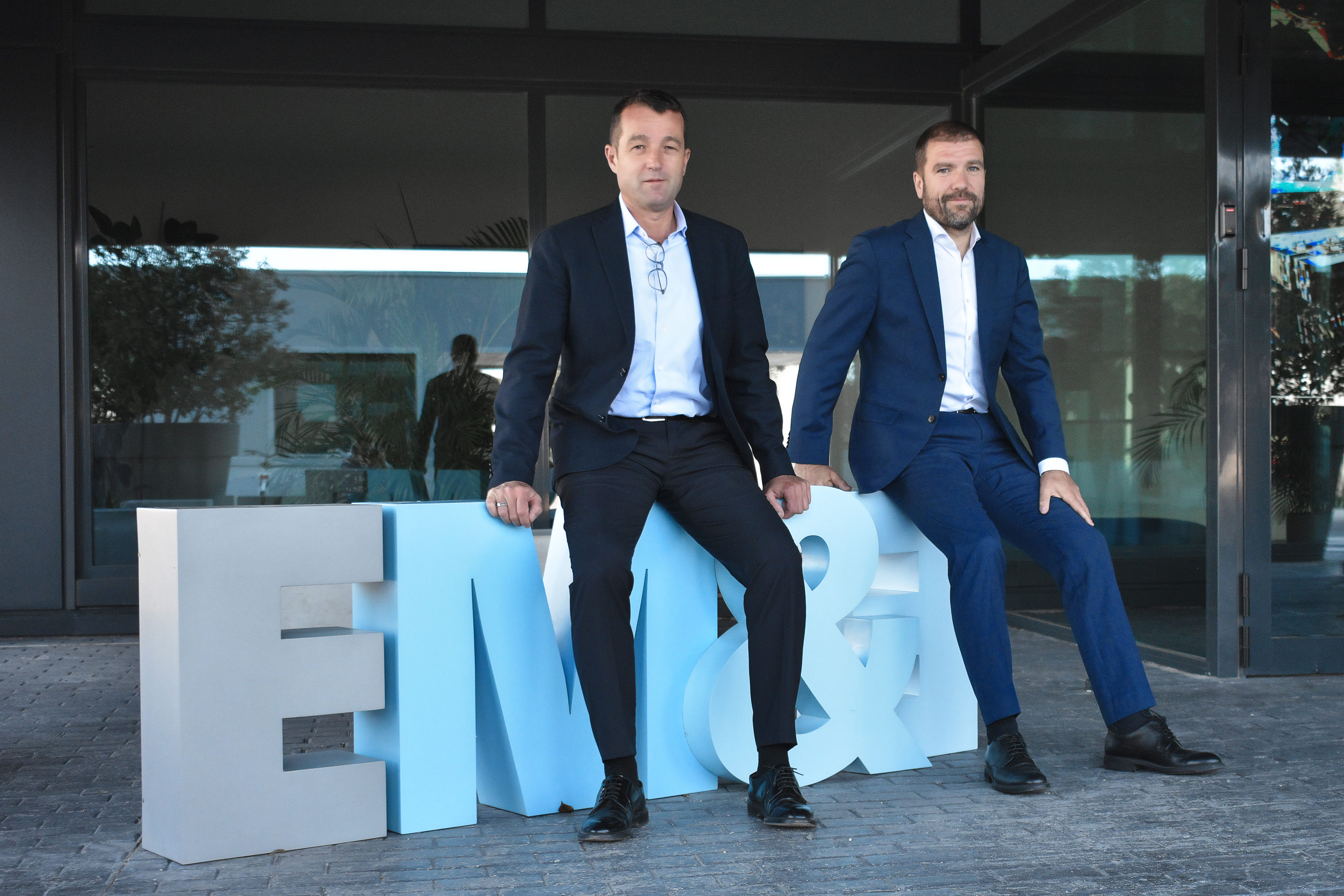 Los hermanos Escribano, Angel y Javier, en la entrada de su sede en Alcalá de Henares.